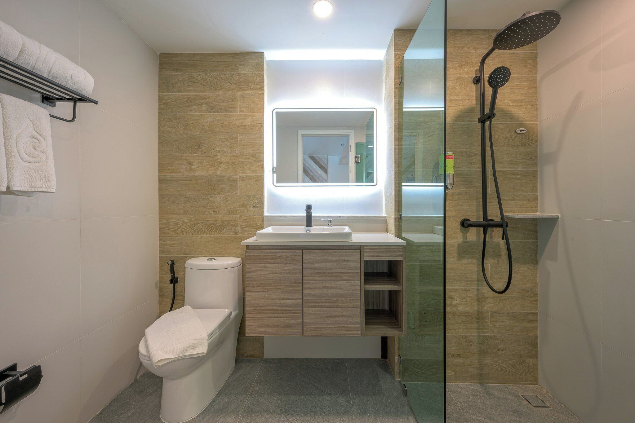 A modern bathroom with a toilet, sink, and shower.