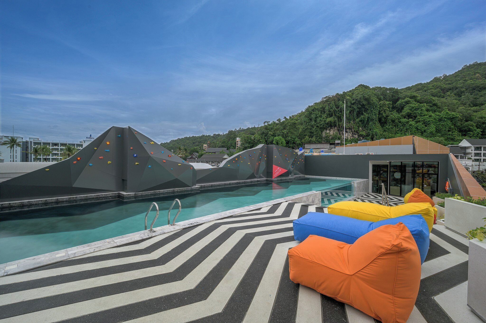 A pool area with climbing walls and colorful bean bags.