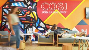 A modern lounge area with colorful wall art, comfortable seating, and a casual atmosphere.