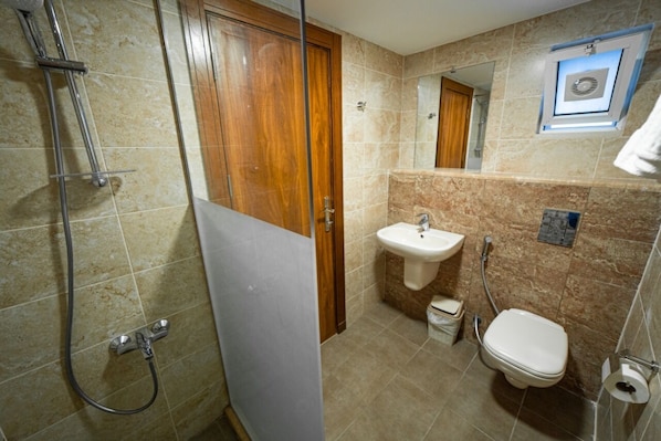 A bathroom with a shower, sink, and toilet.