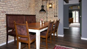 Comedor con pared de ladrillo, mesa de madera y sillas.