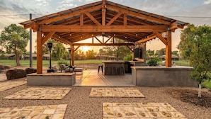A covered outdoor patio with a wooden roof, seating area, and a bar. - Relax & Play -Ultimate Retreat- Pickleball & more! (Scottsdale)