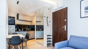 Une cuisine moderne avec un coin repas, un canapé et une porte en bois.