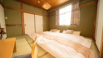 Une chambre de style japonais traditionnel, avec un sol recouvert de tatamis, un lit bas en bois et un paravent shoji.