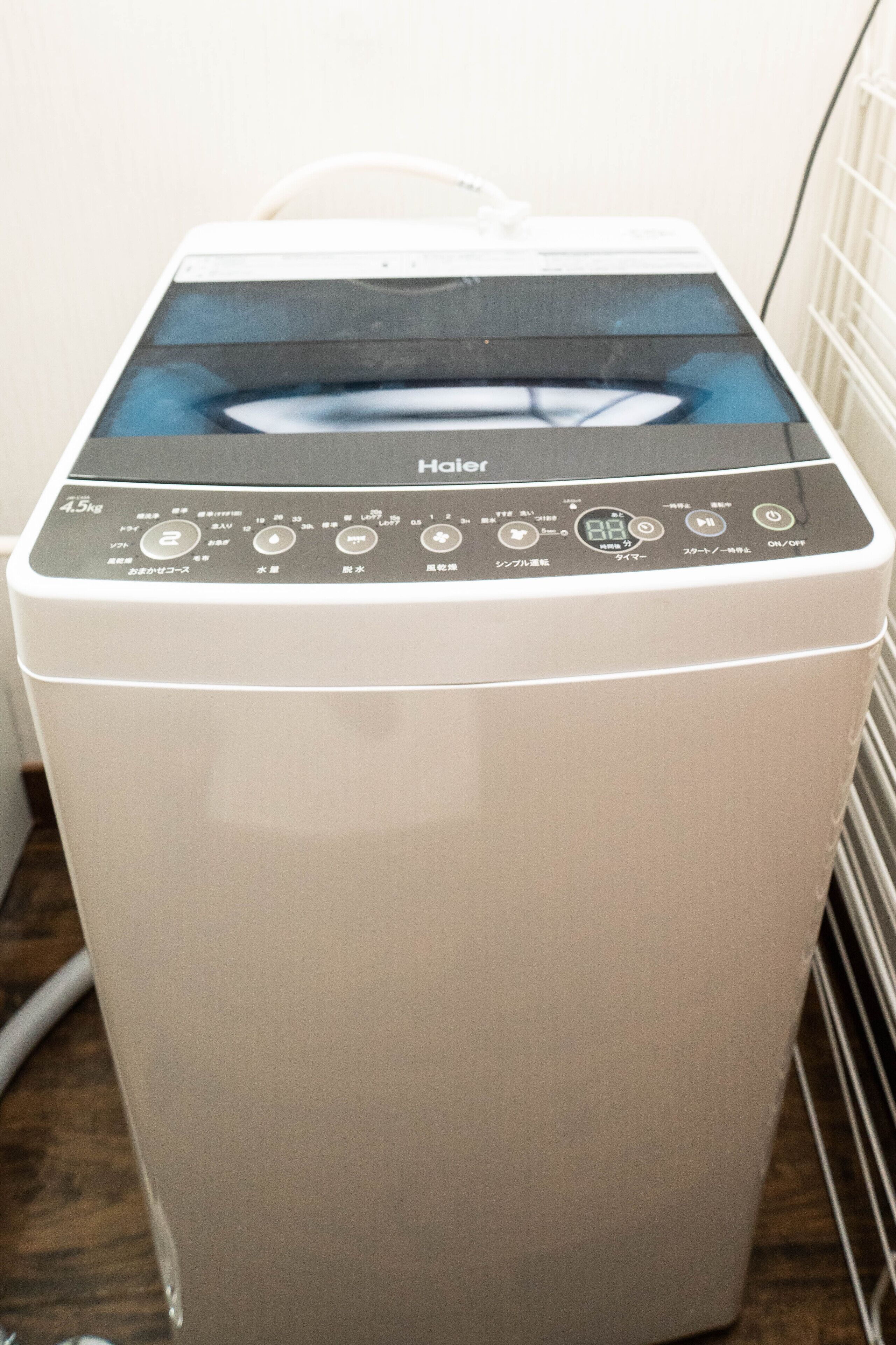 A front view of a white, front-loading washer and dryer unit with a digital control panel displaying various settings and options.