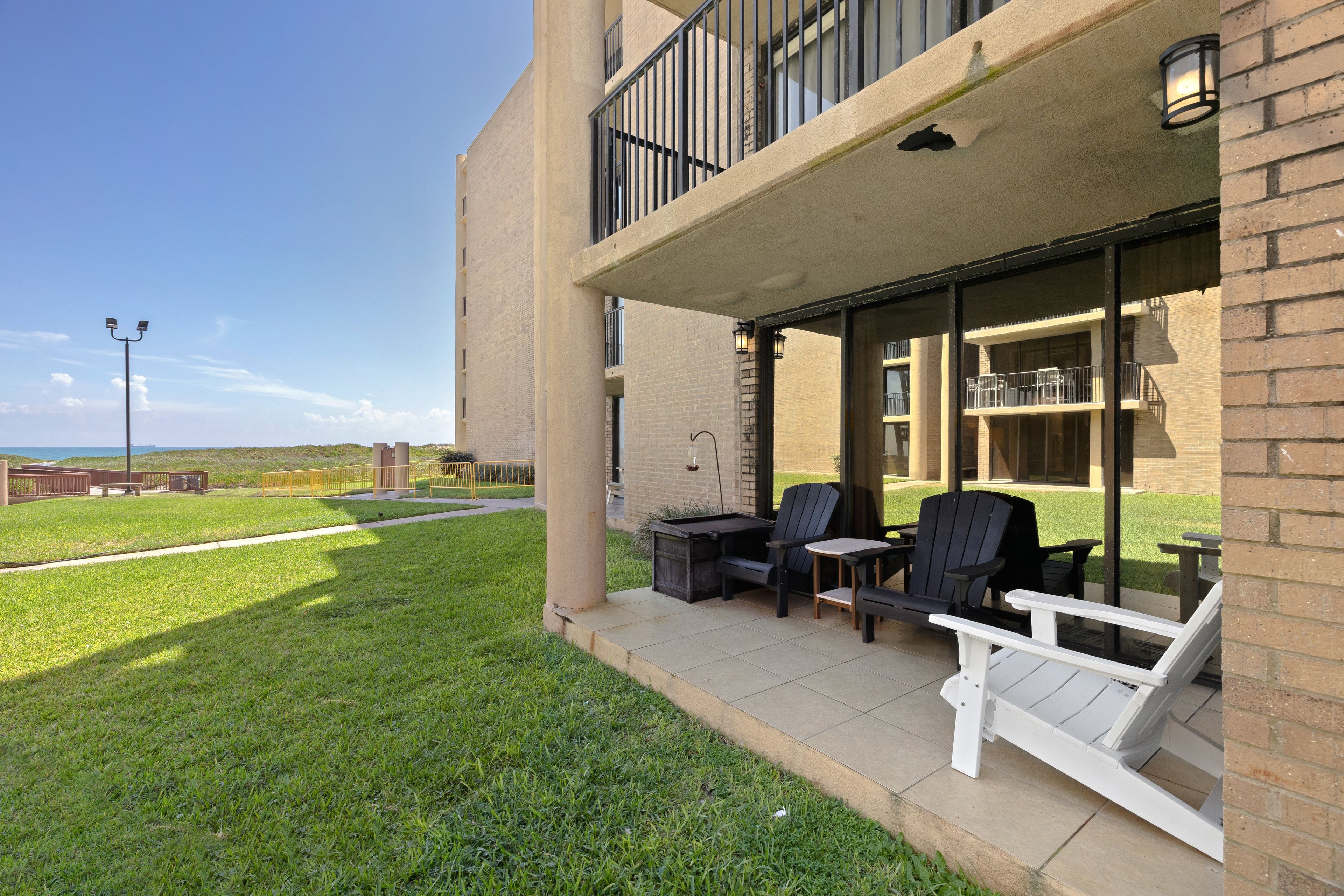 Ein Gebäude mit einer Terrassenfläche, Sitzgelegenheiten im Freien und Blick auf die umliegende Landschaft.