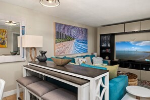 A living room with a TV, a painting, and a bowl on the table.