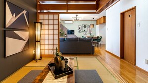Un interior japonés tradicional con suelo de tatami, una mesa de madera baja y una puerta corredera.