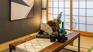 Una habitación japonesa tradicional con suelo de tatami, una mesa de madera baja y paneles shoji.