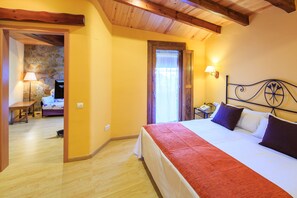Un dormitorio con cama, mesita de noche, lámpara y pared de piedra.