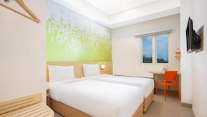 Une chambre d’hôtel avec deux lits, un bureau, une chaise, une télévision et une fenêtre.