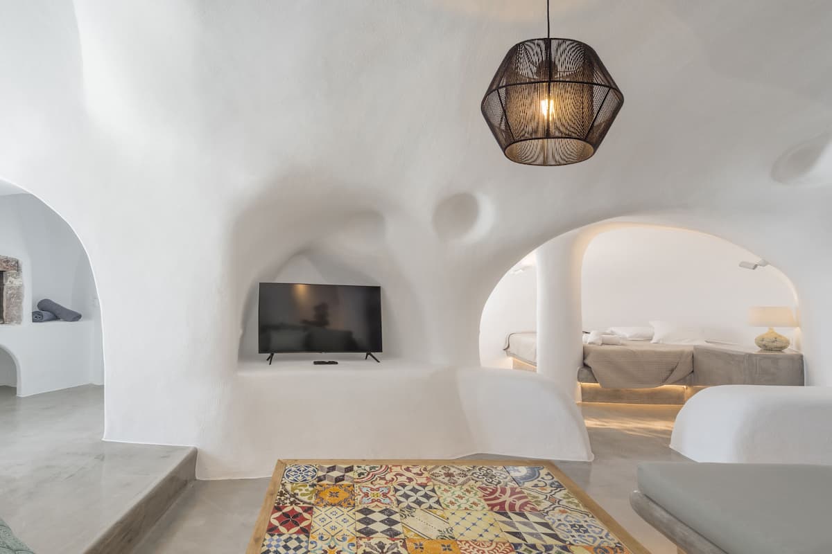 Una sala moderna con chimenea, televisor de pantalla plana y una mesa de centro de cerámica con diseños coloridos.