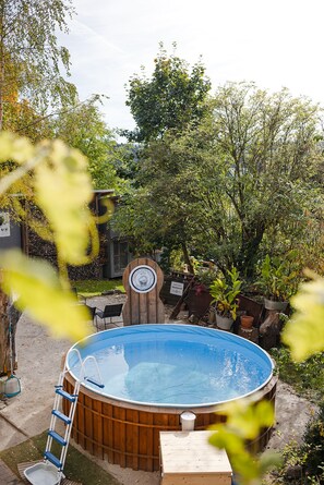 A hot tub surrounded by a garden with trees and plants. - Dreamy GARDEN LOFT (Marienberg)