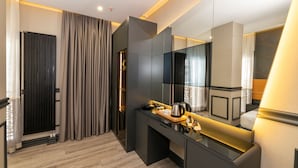 A modern hotel room with a large mirror, a built-in desk, and a separate seating area. - Confores Hotel (Istanbul)