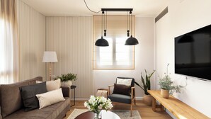 A modern living room with a sofa, armchair, coffee table, and potted plants. - AirTLV - Arlozorov Apartment's (Ramat Gan)