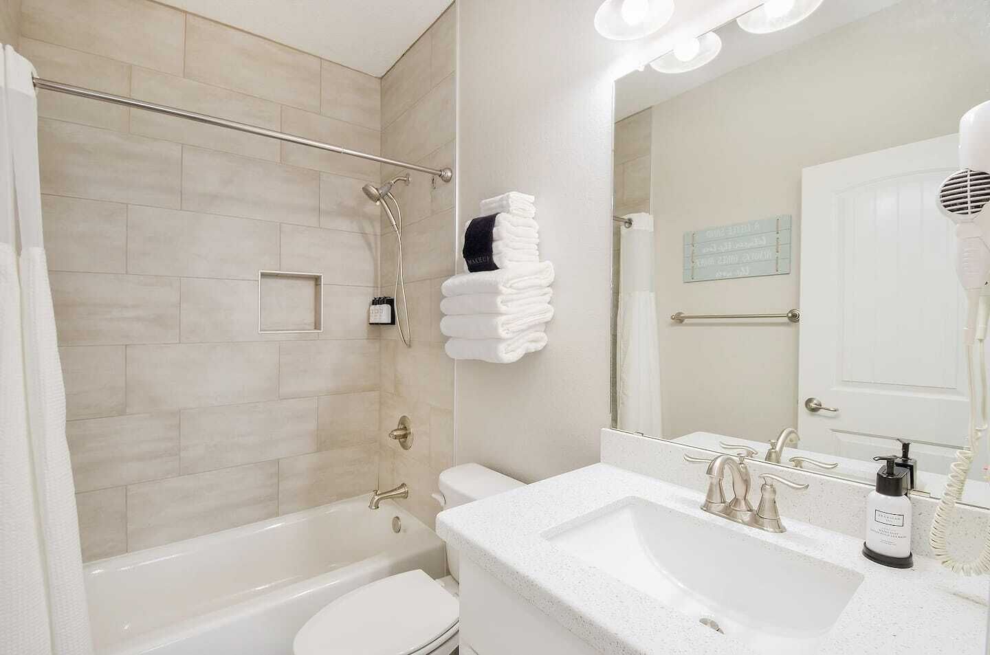 Une salle de bain moderne équipée d’une douche, de toilettes et d’un lavabo.