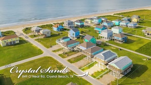 An aerial view of a coastal residential area with houses, a beach, and a road. - Crystal Sands - 3 bedroom, 2 bath home that sleeps 8 - Easy Beach Access! (Crystal Beach)