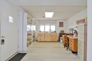 A room with a wooden desk, filing cabinets, and shelves with various items.