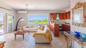 Ein Wohnzimmer mit Sofa, Couchtisch und Meerblick.
