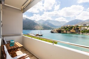 A balcony with a view of a lake, boats, and mountains. - Ocean Dream, a 2 bedroom apt on the beach! (Rethymno)