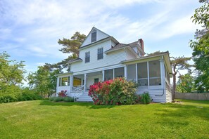 A two-story house with a covered porch and a well-maintained lawn.