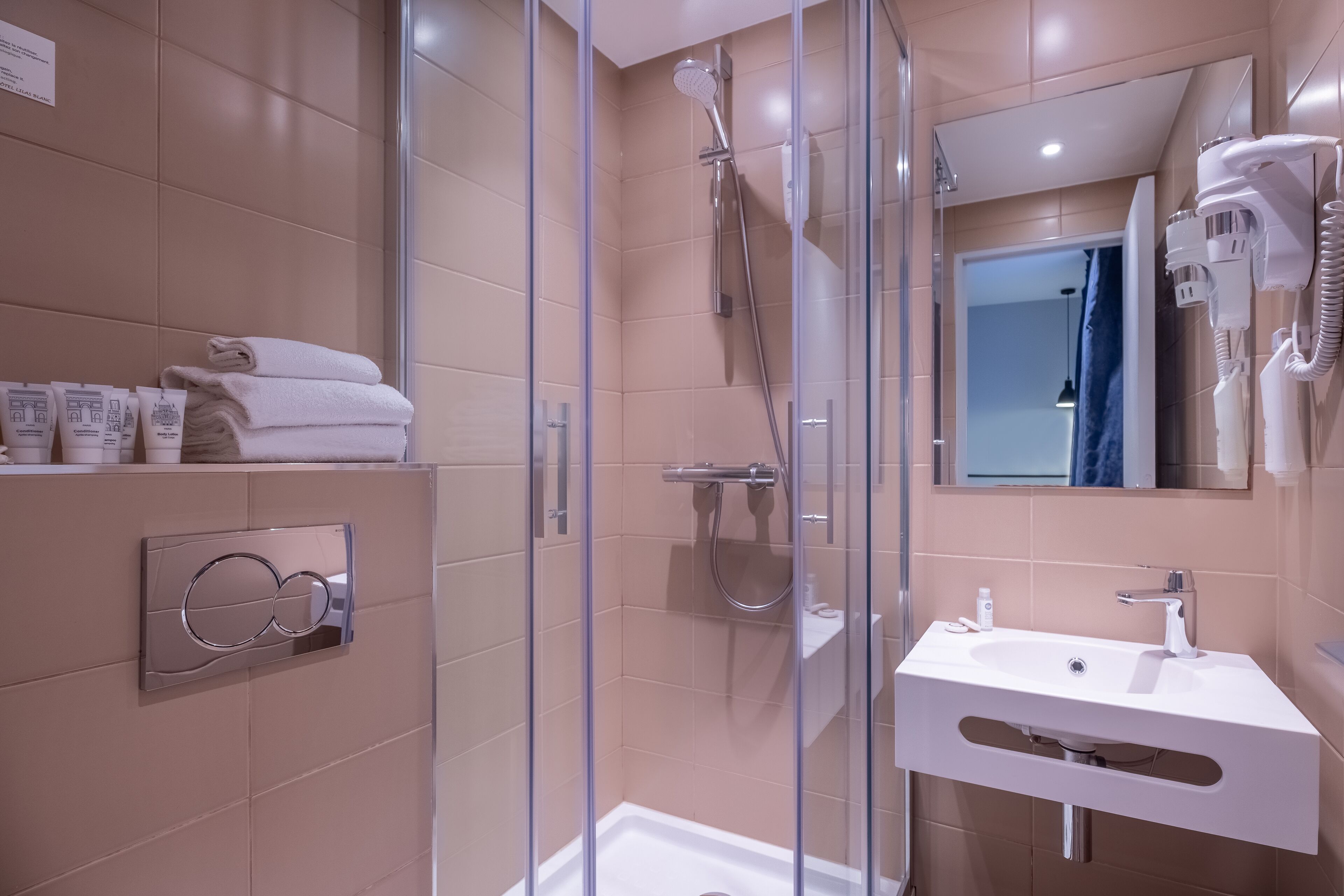 A modern bathroom with a glass-enclosed shower, a white sink, and a towel rack with neatly folded towels.