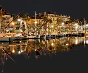 A marina at night with boats docked, buildings in the background, and lights reflecting on the water. - Renovated bastide, Capelan Peninsula, quiet (Bandol)