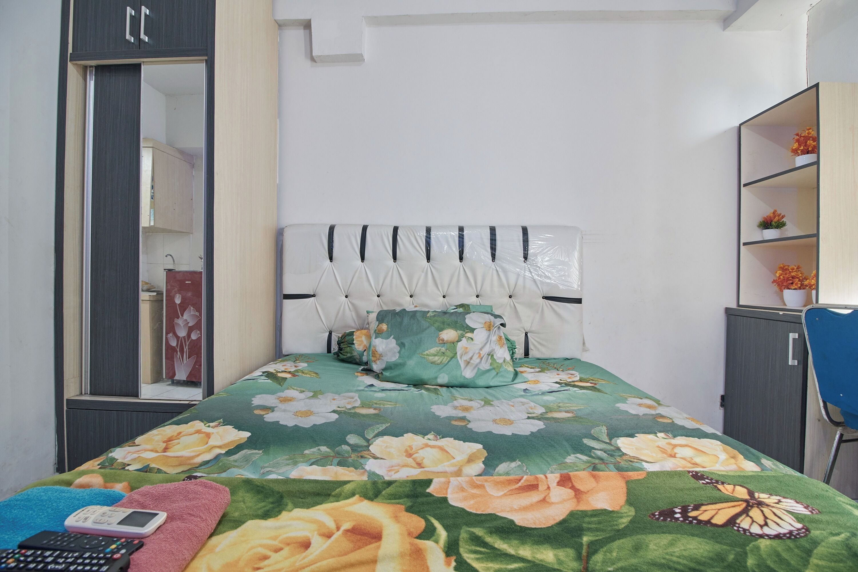 Ein Schlafzimmer mit Bett, Kleiderschrank, Schreibtisch und Stuhl.
