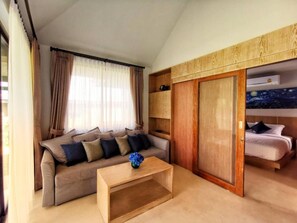 Relax in a cozy space with a comfortable sofa, coffee table, and simple bed.