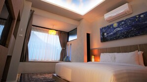 Habitación de hotel con tragaluz, un cuadro, una cama y una ventana con cortinas.