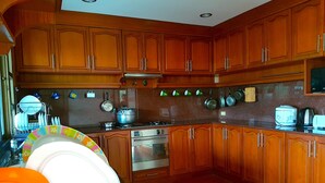 Una cocina con armarios de madera, estufa, horno y escurreplatos.