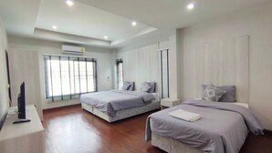 A modern hotel room with two beds, a flat-screen TV, and a large window with blinds. - Lan House Pool Villa (Chiang Mai)