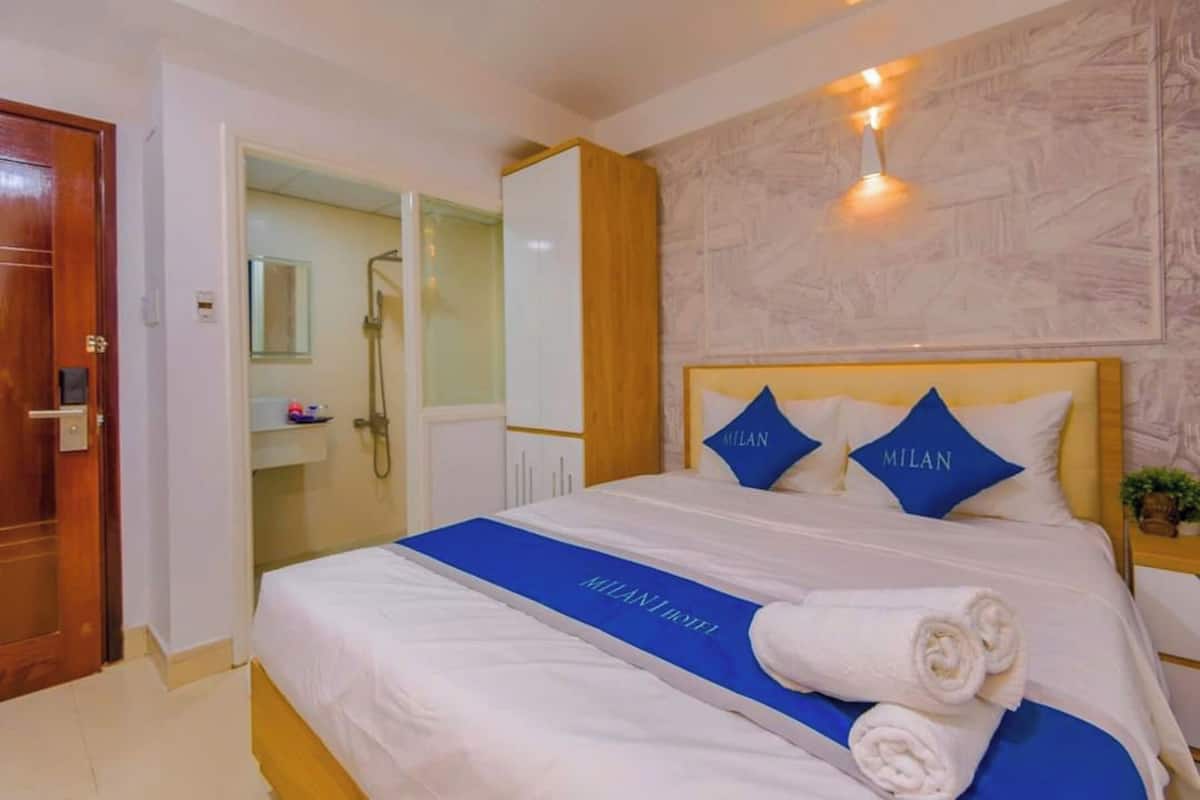 Une chambre d’hôtel avec un lit, une salle de bain et une porte en bois.