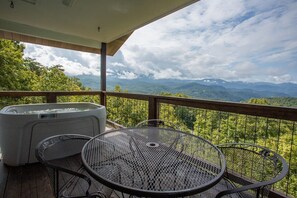 A balcony with a hot tub, two metal chairs, and a scenic mountain view. - Postcard View of GSMNP/3.6 Miles 2 DwTn Gatlinburg (Gatlinburg)