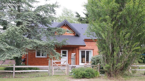 Een houten chalet met schuin dak, een voordeur en een klein raam.