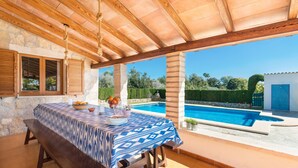 A covered outdoor dining area with a pool in the background. - YESERO. Beautiful villa near Pollensa (Pollensa)
