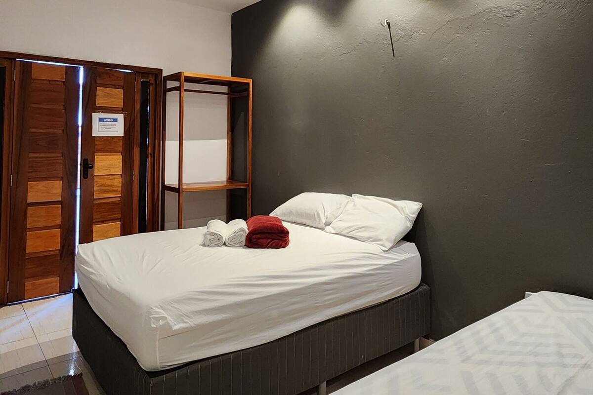 A bedroom with a bed, a wardrobe, and a built-in shelf unit.