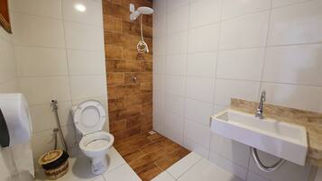 A bathroom with a shower, toilet, and sink.