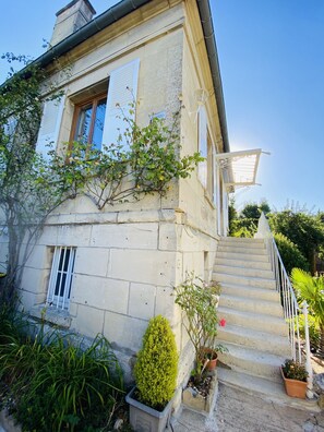 A stone building with a staircase leading to a balcony.