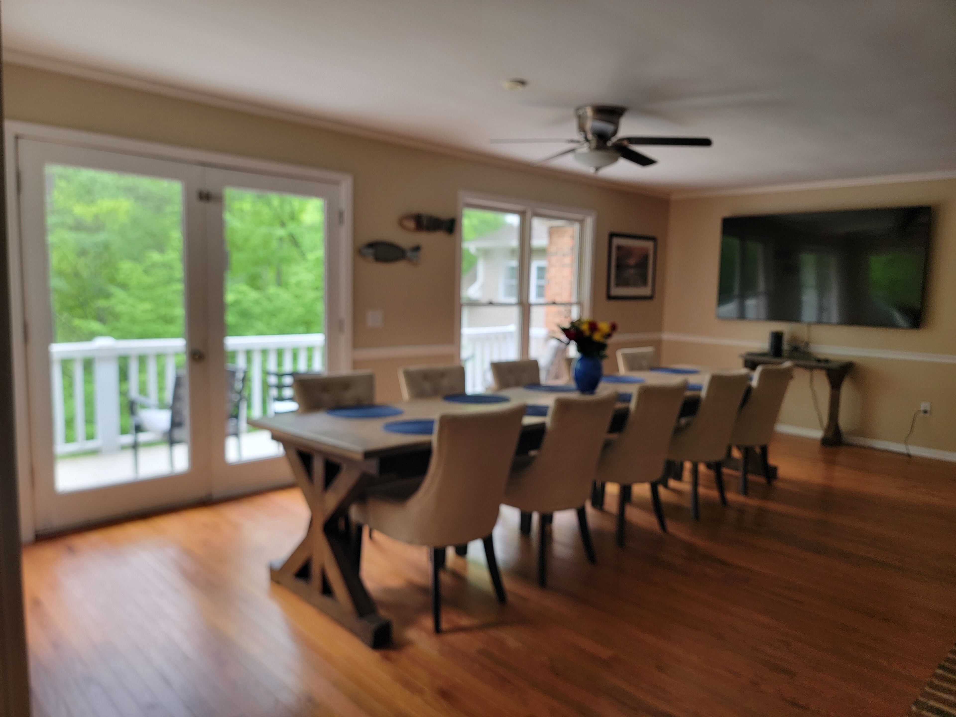 Huge 85" TV in dining room with custom herringbone oak table.