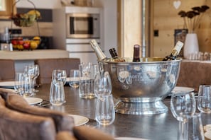 Eine Bar mit einem Champagnerkühlbag, Gläsern und einem Esszimmertisch, der für eine Mahlzeit gedeckt ist.