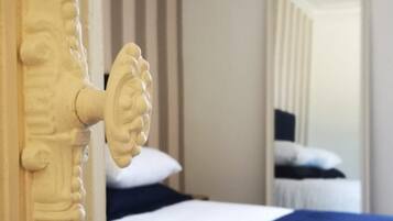 Ein Schlafzimmer mit einem Bett, einem Holz-Kopfteil und einem Spiegel, der den Raum widerspiegelt.