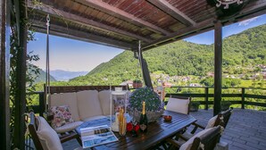 Un espacio al aire libre cubierto con una mesa de madera, sillas y un sofá.