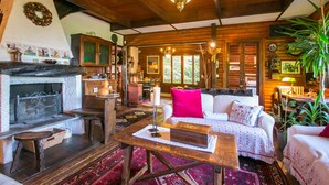 Interior acogedor de una cabaña de madera con chimenea, mobiliario de madera y un comedor.