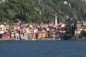 A coastal town with colorful buildings, a prominent church tower, and a waterfront with boats. - Vista su Perledo (Perledo)