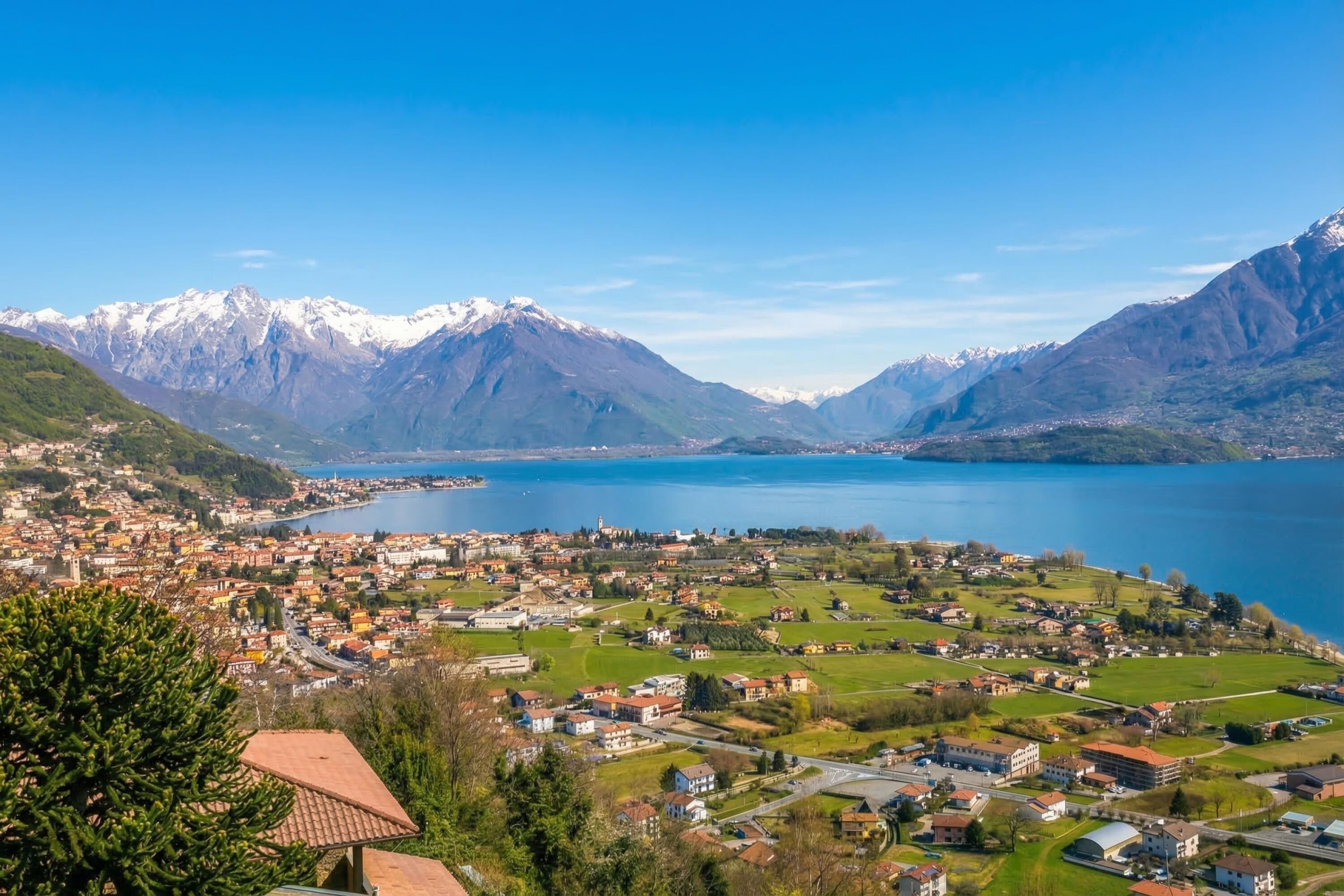 A town with a lake, mountains, and a clear sky.