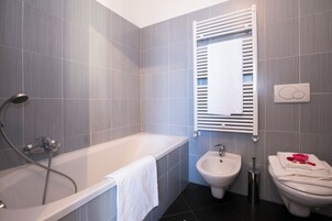 Családi apartman, több hálószobával, két fürdőszobával, hegy felőli (Borgo La Sorgente - Dolce Vita) | Fürdőszoba | Külön fürdőkád, illetve zuhanyzó, esőzuhany és ingyenes piperecikkek