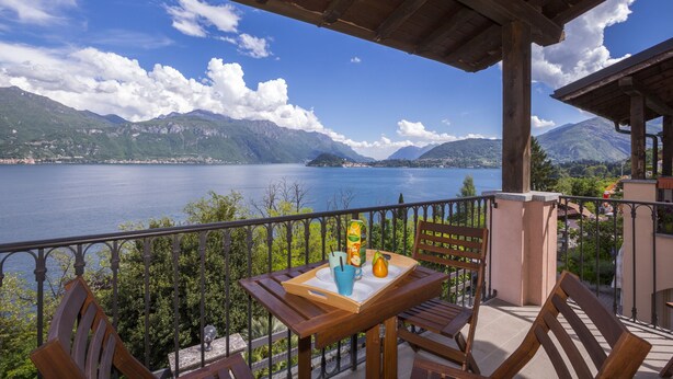 A wooden table with a tray, a chair, and a view of a lake and mountains.