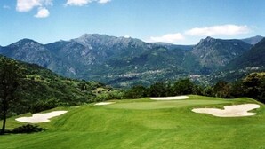 A golf course with a clear view of mountains in the background.