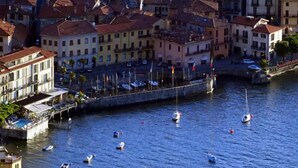 A coastal town with buildings along the waterfront, boats in the water, and a dock area.